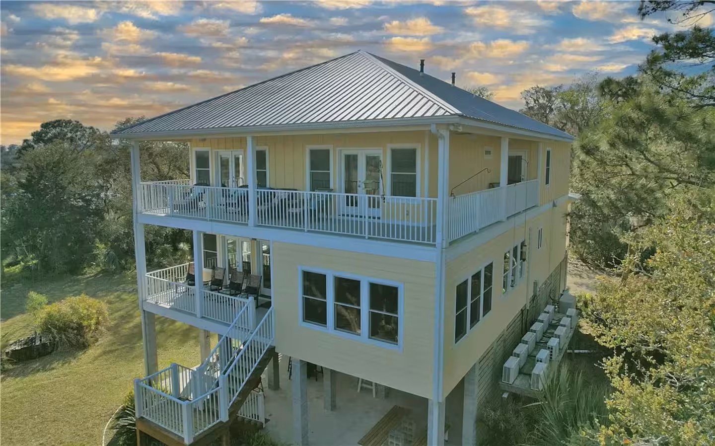 Aerial view of Blue Heron Waterfront Home surrounded by trees and marshland