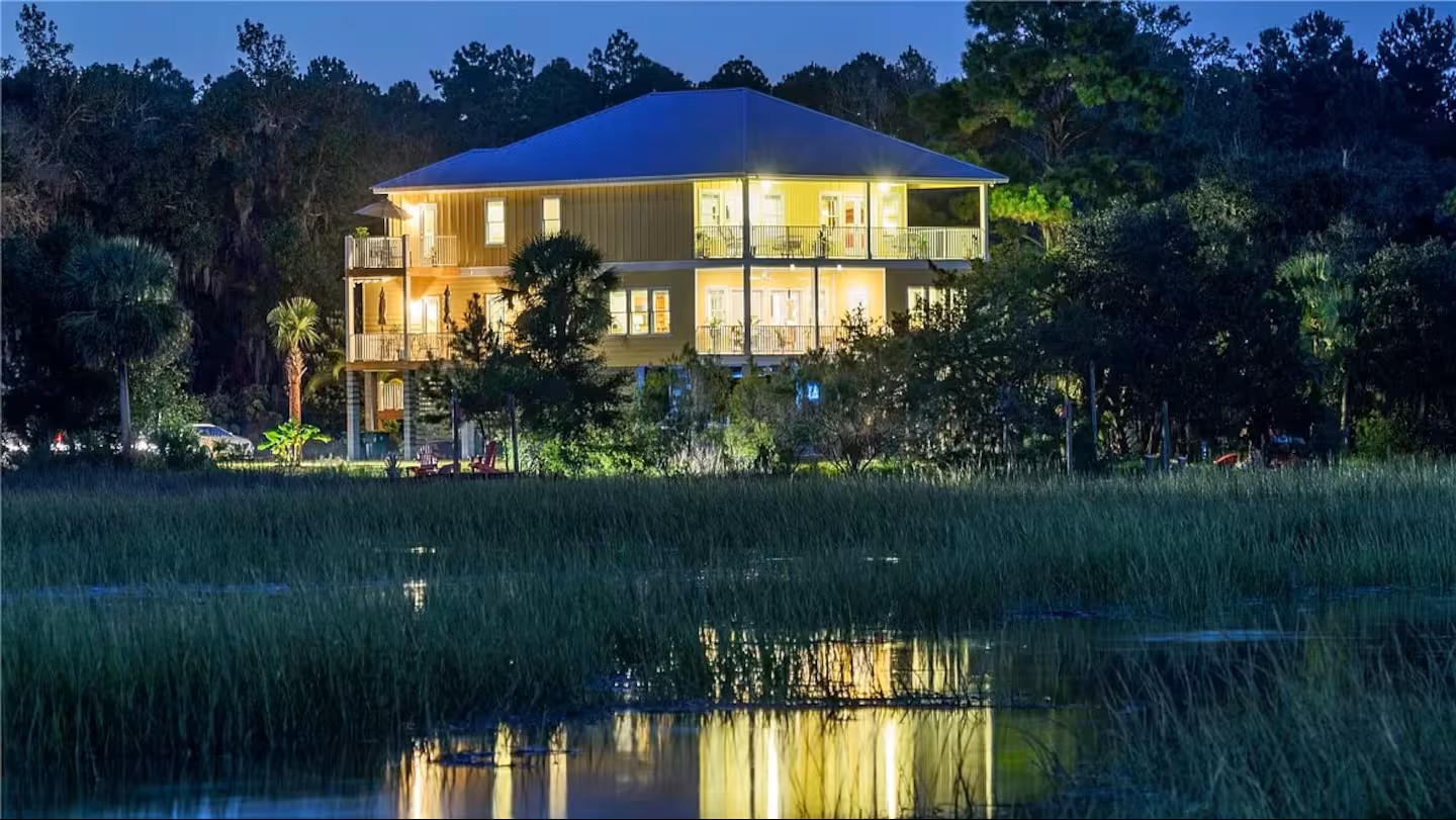 Blue Heron Waterfront Home glowing at dusk, welcoming guests for evening arrival
